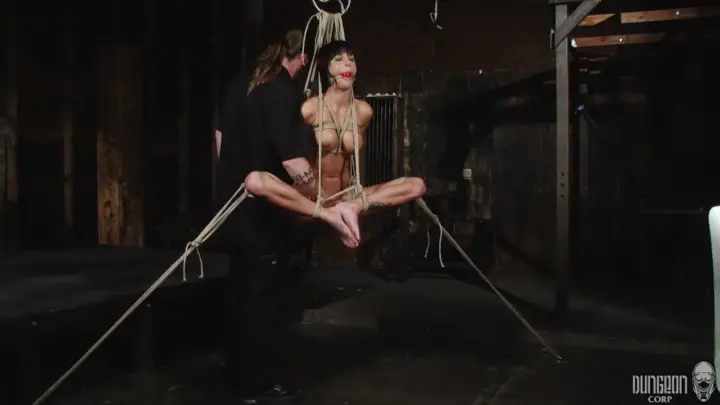 Two slim Asian girls and a white guy in rope bondage warehouse scene