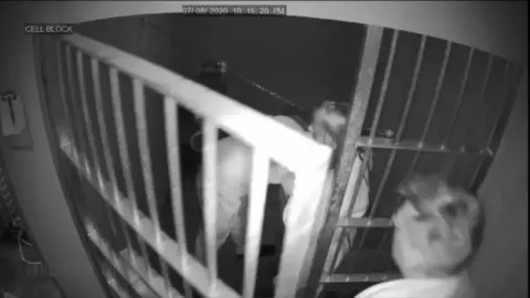 Two slim white girls fuck in prison cell with bars and masks