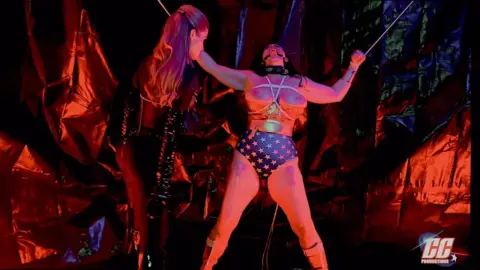 Compound XXX – Dark-Haired Brunette and Blonde in BDSM Rope Scene